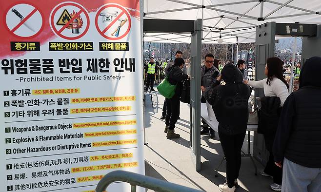 방탄소년단(BTS) 컴백 공연 당일인 21일 서울 종로구 광화문광장에서 팬들이 입장하며 검색대를 지나고 있다. 뉴시스