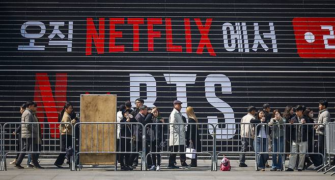 방탄소년단(BTS)의 서울 광화문광장 컴백 공연을 앞둔 지난 17일 서울 종로구 세종문화회관 계단에서 시민과 여행객들이 방탄소년단 랩핑과 사진을 찍고 있다. 뉴시스