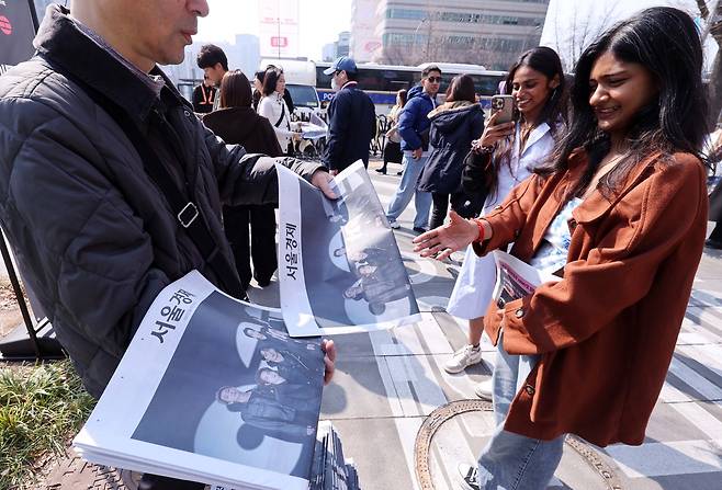 21일 서울 광화문 광장에서 그룹 방탄소년단(BTS)의 ‘BTS 컴백 라이브: 아리랑’(BTS THE COMEBACK LIVE | ARIRANG) 무료 복귀 공연이 열리는 가운데 외국인 팬이 서울경제 호외를 받고 있다. 이날 BTS는 공연에서 1시간에 걸쳐 신곡과 히트곡을 들려줄 예정이다. 권욱 기자