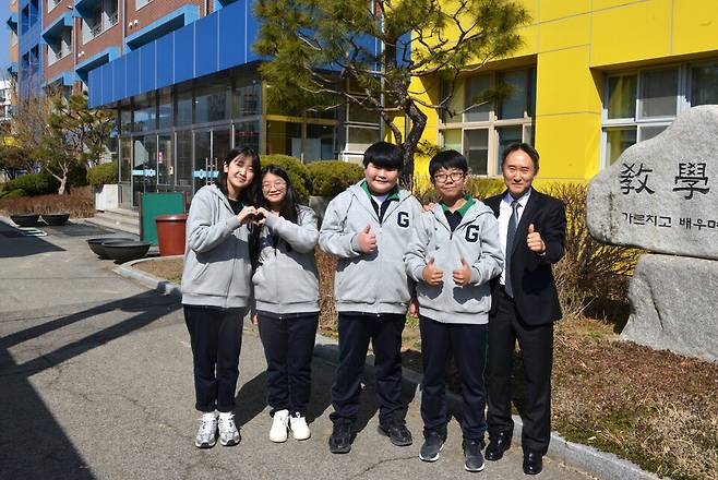 ▲ 의정부시 금오중학교 원영식(오른쪽 첫 번째) 교장과 이 학교 1학년생들이 지난 13일 생활형 교복을 입고 본관 입구에서 밝은 미소를 띠고 있다.