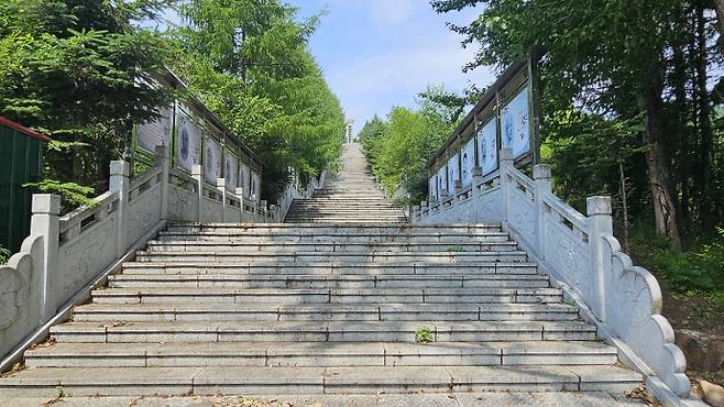 중국 길림성 화룡현 청산리 어랑촌에 위치한 '어랑촌13용사기념비'로 가는 길목. 203개의 계단 양 옆에서 어랑촌 항일 영웅 들의 간단한 설명과 초상화 등이 나열돼 있다. 만주/김성빈 기자 ksb@namdonews.com
