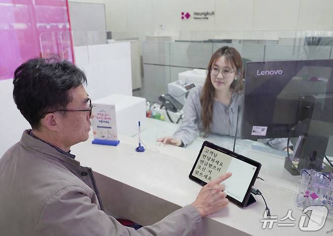 서울 종로구 흥국생명 본사 금융플라자에서 고령 고객과 직원이 ‘AI 실시간 자막 서비스’를 이용해 금융 상담을 진행하고 있다/사진제공=흥국생명