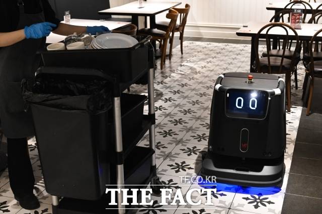 지난 13일 오후 서울 천호동 애슐리퀸즈에 서빙 로봇과 청소 로봇이 홀을 돌아다니고 있다. /남윤호 기자