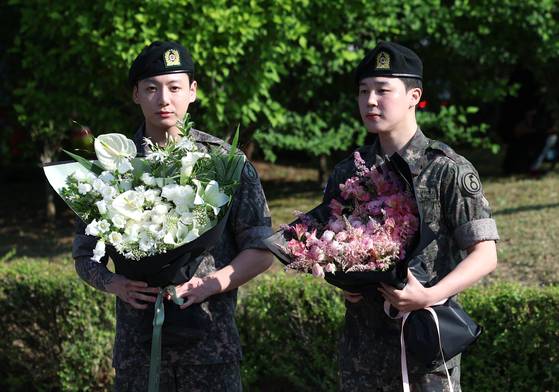 방탄소년단(BTS)의 정국과 지민(오른쪽)이 경기도 연천군 연천공설운동장에서 군 복무를 마친 뒤 전역 인사를 하는 모습. 뉴스1