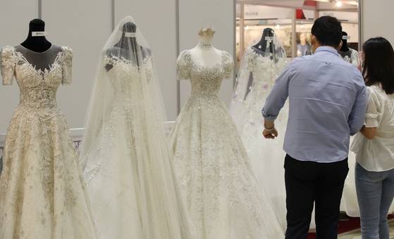 예비 신랑 신부가 웨딩드레스를 둘러보고 있다. 연합뉴스