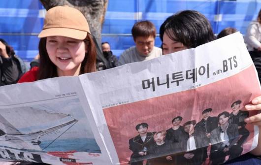 BTS(방탄소년단) 컴백 공연일인 21일 오전 서울 광화문광장 인근에서 외국인 관광객이 주요 신문사의 BTS 관련 호외를 보고 있다. / 사진 = 뉴스1