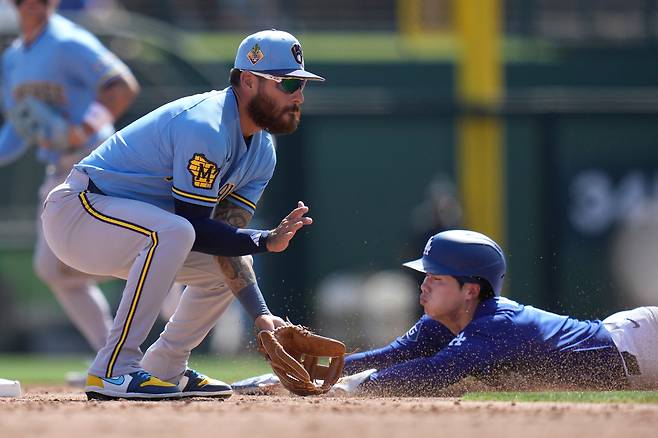 Los Angeles Dodgers' Hyeseong Kim, right, of South Korea, steals second base as Milwaukee Brewers shortstop Joey Ortiz waits for a late throw during the third inning of a spring training baseball game, Monday, March 16, 2026, in Phoenix. (AP Photo/Ross D. Franklin)
