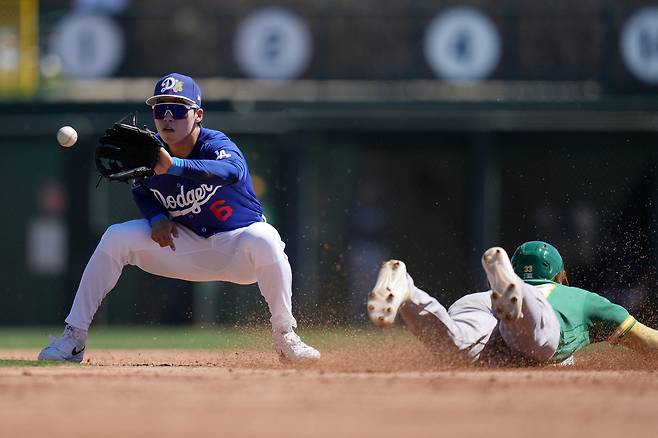 Athletics' Henry Bolte, right, steals second base as Los Angeles Dodgers shortstop Hyeseong Kim (6), of South Korea, gets a late throw during the second inning of a spring training baseball game, Saturday, March 21, 2026, in Phoenix. (AP Photo/Ross D. Franklin)
