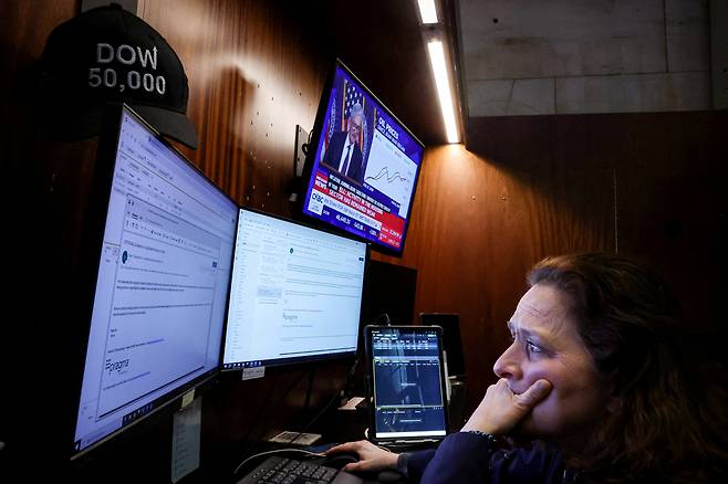미국 뉴욕증권거래소(NYSE)에서 18일(현지 시간) 제롬 파월 연방준비제도(Fed) 의장의 기자회견 중계가 재생되는 가운데 한 트레이더가 업무를 보고 있다. 로이터연합뉴스