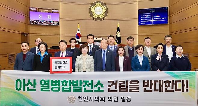 천안시의회 의원들이 23일 열린 제287회 임시회 제1차 본회의에서 '아산 열병합발전소 건립 반대 결의안'을 만장일치로 채택하고 사진촬영을 하고있다. ⓒ천안시의회 제공