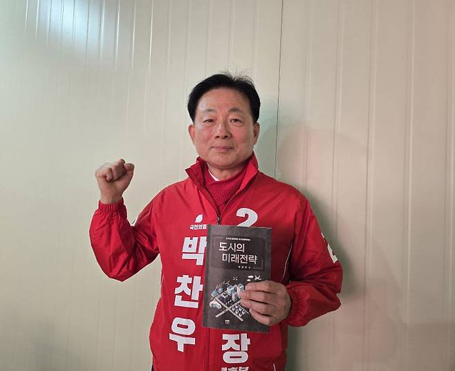 박찬우 천안시장 예비후보가 자신의 정책서인 '도시의 미래전략'을 들고 파이팅을 외치고 있다.(사진=하재원 기자)