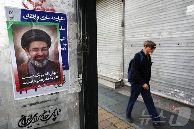 22일 이란 수도 테헤란의 한 거리에 새 최고지도자인 모즈타바 하메네이의 포스터가 붙어 있다. 2026.3.22 ⓒ 로이터=뉴스1