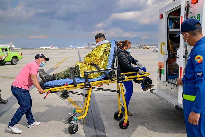 콜롬비아군 공보실이 배포한 사진에 23일(현지 시간) 콜롬비아 푸에르토 레기사모에서 이륙 직후 추락한 콜롬비아군 수송기 부상자들이 보고타에 있는 군 기지로 후송돼 구급차에 탑승하고 있다. 2026.03.24 보고타=AP/뉴시스