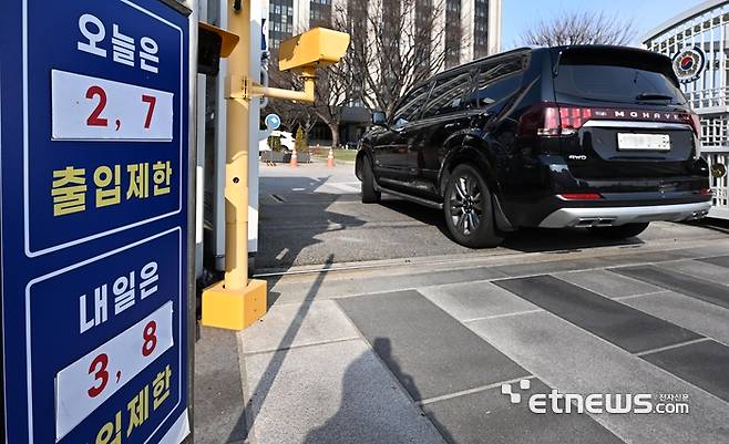정부가 중동지역 전쟁으로 발생한 에너지 수급 위기에 대비해 공공부문 승용차 5부제(요일제)를 의무적으로 시행한다. 단 전기차나 수소차는 제외한다. 24일 서울 종로구 정부서울청사 출입구에 5부제 안내판에 세워져 있다.  이동근기자 foto@etnews.com