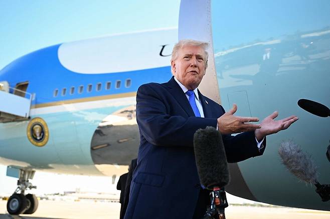 도널드 트럼프 미국 대통령이 23일(현지시각) 플로리다주 팜비치 국제공항에서 에어포스원 탑승에 앞서 기자들과 대화하고 있다. 웨스트팜비치/AFP 연합뉴스