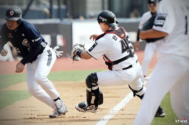 [서울=뉴시스] 프로야구 KT 위즈 한승택이 23일 수원 KT위즈파크에서 열린 2026 신한 쏠 KBO리그 시범경기 두산 베어스전에서 달리는 상대 주자를 잡고 있다. (사진=KT 위즈 제공) 2026.03.23. *재판매 및 DB 금지