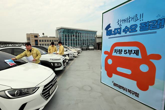 24일 오후 광주 북구 효죽2주차장 4층에서 구청 에너지정책팀 직원들이 차량 유리창에 승용차 요일제 안내문을 부착하고 있다. 연합뉴스