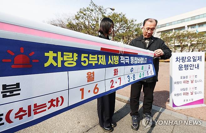 내일부터 공공부문 승용차 5부제 (군포=연합뉴스) 홍기원 기자 = 24일 경기도 군포시청에서 관계자들이 25일 0시부터 시작되는 공공부문 승용차 5부제를 앞두고 주차 차단봉에 안내문을 붙이고 있다. 군포시는 중동 사태에 따른 국제 유가 불안정에 대응해 지난 19일부터 '공직자 차량 5부제'를 시행하고 있다. 2026.3.24 xanadu@yna.co.kr