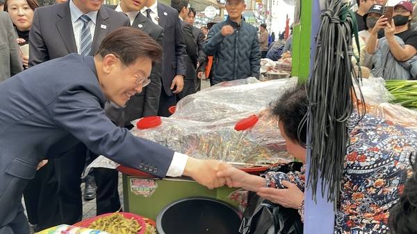 이재명 대통령이 25일 오후 진주 중앙시장을 방문해 상인과 시장을 찾은 시민들과 인사를 나누고 있다. /독자
