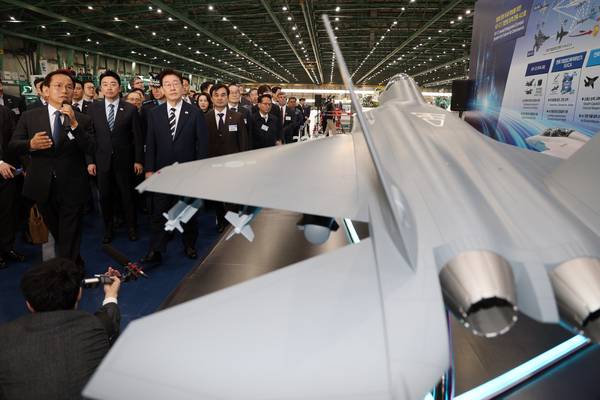 이재명 대통령이 25일 경남 사천 한국항공우주산업(KAI)에서 KF-21 양산 1호기 출고식 후 전투 시스템 관련 설명을 듣고 있다. /연합뉴스