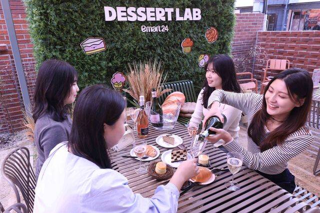 이마트24 ‘디저트랩 서울숲점’은 일매출이 2.2배 증가했다. 사진은 이달 13일 새롭게 선보인 이마트24 ‘디저트랩 서울숲점’의 야외 테라스에서 모델들이 디저트와 논알콜 와인을 페어링해 즐기고 있다. ‘디저트랩 서울숲점’은 디저트 상품 구색을 대폭 확대해, 이마트24의 신상품은 물론 트렌디한 디저트/베이커리 상품을 한자리에서 경험할 수 있도록 했다.(이마트24 제공)