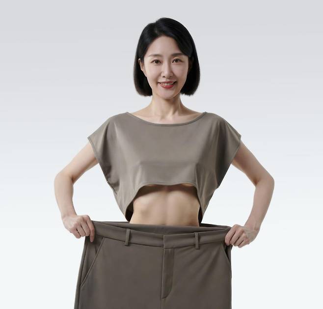 체중 감량 후 헐거워진 바지를 들어 보이는 여성. 연구에 따르면 폐경 이후 여성은 호르몬 치료를 병행할 경우 비만 치료 효과가 더 높아질 수 있다. 게티이미지뱅크