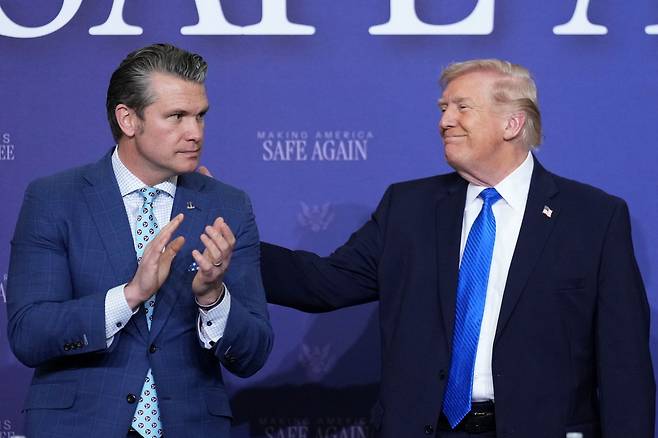 23일(현지시간) 미국 테네시주 군기지에서 도널드 트럼프 대통령(오른쪽)이 피트 헤그세스 전쟁부(국방부) 장관을 두드리고 있다. 트럼프는 “이란 에너지 인프라 공습을 5일간 유예하겠다”고 밝혔다. [AP=연합뉴스]