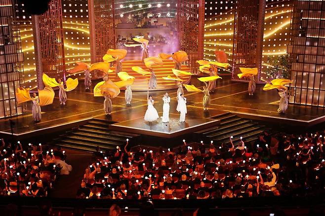 '골든' 무대의 후반부. 이재, 레이 아미, 오드리 누나가 대한제국 당시의 복장에 영감받은 옷을 입고 노래를 부른다. 뒤에 선 무용수들은 혼문을 상징하는 황금 깃발을 휘두르며 군무를 추고 있다. EPA=연합뉴스