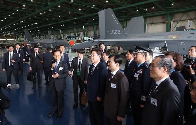 이재명 대통령이 25일 오후 경남 사천 한국항공우주산업(KAI)에서 KF-21 양산 1호기 출고식을 마친 뒤 관계자들과 생산 현장 시찰을 하고 있다. 20260324 청와대사진기자단 김호영기자