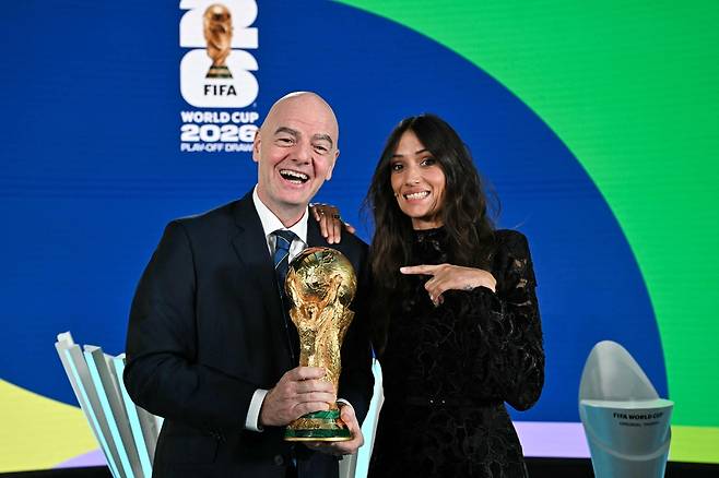 잔니 인판티노 국제축구연맹(FIFA) 회장(왼쪽)과 스위스 배우 멜라니 위니거가 2025년 11월 20일 스위스 취리히 FIFA 본부에서 열린 2026 북중미 월드컵 유럽 플레이오프 대진 추첨 행사에서 월드컵 트로피와 함께 포즈를 취하고 있다. AFP
