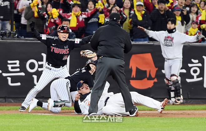 LG 신민재(가운데)이 29일 대전 한화생명볼파크에서 열린 2025 KBO리그 한화와 한국시리즈 3차전 3회초 2사 1루 상황에서 1타점 2루타를 치고 3루까지 달려 한화 노시환의 태그를 피한 뒤 3루심을 바라보고 있다. 대전 | 박진업 기자 upandup@sportsseoul.com