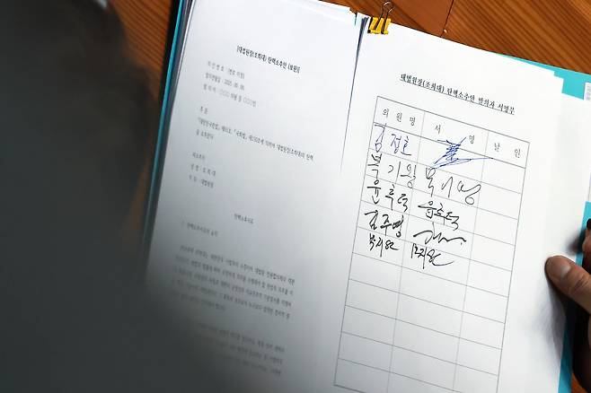 19일 국회에서 열린 3월 임시국회 2차 본회의에서 더불어민주당 민형배 의원이 의원들에게 조희대 대법원장 탄핵소추안 발의 서명을 받고 있다. 연합뉴스