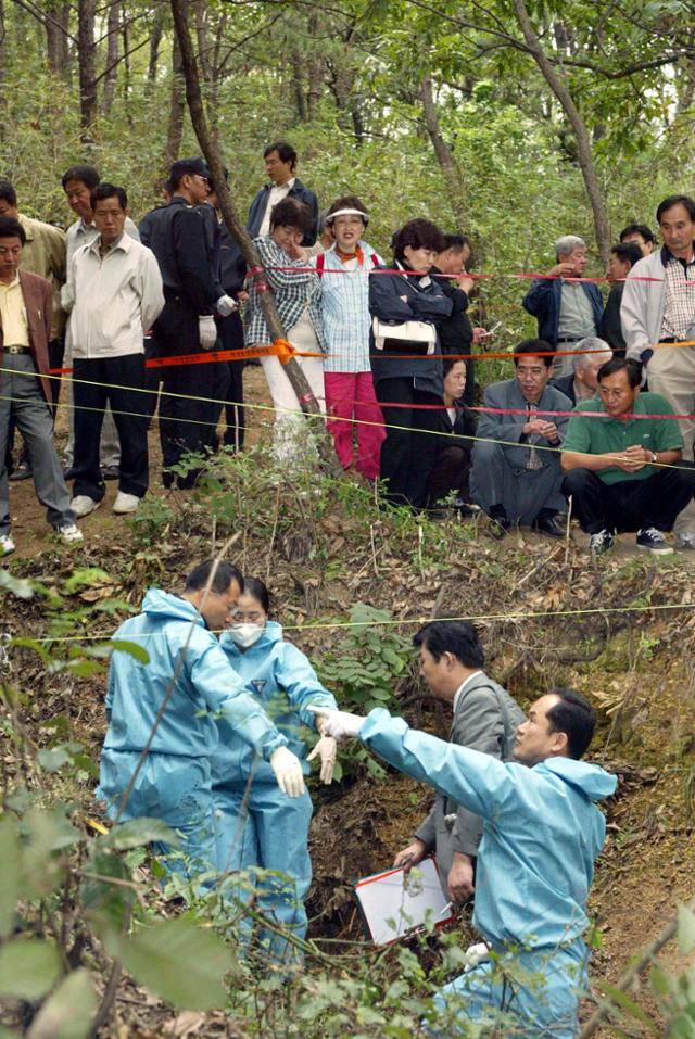국립과학수사대 검사관들이 2002년 9월 27일 대구시 달서구 용산동 와룡산 산기슭에서 발견된 개구리소년들의 발굴현장에서 감식 작업을 하고 있다. 한국일보 자료사진