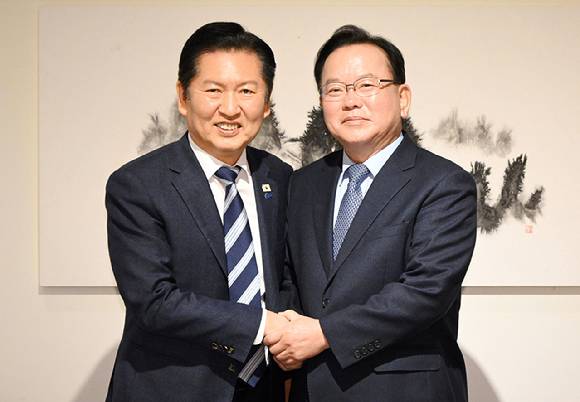 더불어민주당 정청래 대표와 김부겸 전 국무총리가 26일 서울 중구 달개비에서 회동 전 손을 맞잡고 있다.  [사진=연합뉴스]