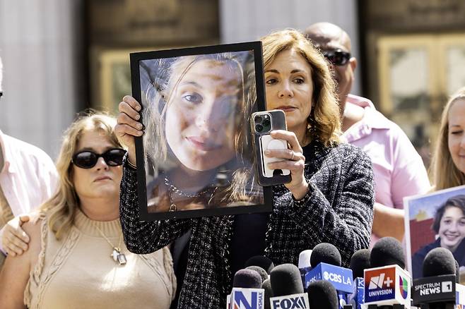 25일(현지시간)사회관계망서비스(SNS) 중독 책임 관련 재판이 열린 가운데 한 여성이 SNS 중독으로 스스로 목숨을 끊은 가족의 사진을 들어 보이고 있다. EPA연합뉴스