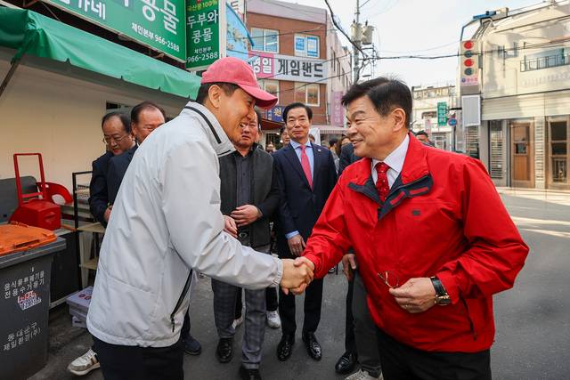 이필형(오른쪽) 동대문구청장과 오세훈(왼쪽) 서울시장이 23일 청량리종합시장 일대에서 악수하고 있다.
