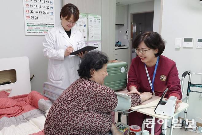25일 충남 천안시의 퇴원 환자 단기 입소 시설 ‘중간집’에서 간호사가 김형자 씨(73·왼쪽)의 혈압을 측정하고 있다. 김씨는 중간집에서 건강을 회복한 뒤 집에서 방문 간호 등 통합돌봄 서비스를 받을 예정이다. 천안=변영욱 기자cut@donga.com