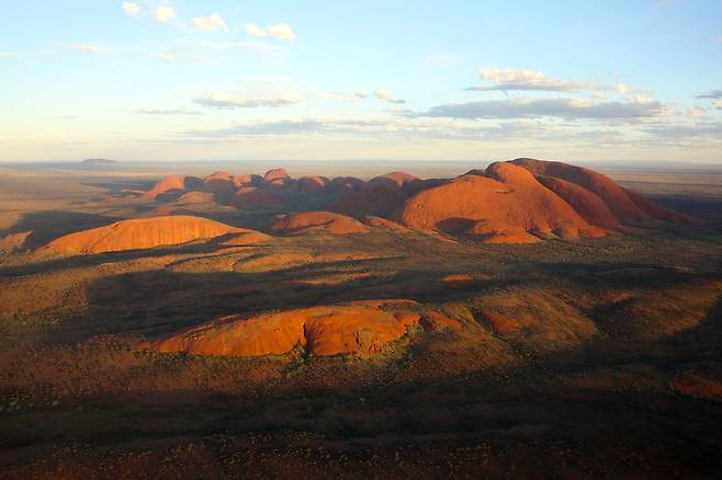 헬기에서 내려다본 카타추타. 울루루와 짝을 이루는 명소이자 성지다. 돌 한 개로 이루어진 울루루와 달리 카타추타는 36개 암봉을 아우르는 돌무더기다. 멀리 울루루가 내다보인다.