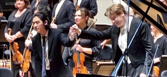 지난 12일 파리 ‘필하모니 드 파리’에서 임윤찬과 클라우스 메켈레가 관객에게 인사하고 있다.  /이주현 기자