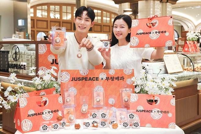 신세계백화점이 전통 제과 브랜드 부창제과와 아티스트 지드래곤의 저스피스 재단이 협업한 'LOVE & PEACE Series'를 26일부터 4월 5일까지 단독으로 선보인다고 밝혔다. 모델들이 스위트파크에서 부창제과X저스피스 협업 호두과자를 선보이고 있다. 사진=신세계백화점 제공