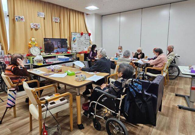 일본 도쿄 다이토구 소재 류센 지역포괄지원센터의 데이케어 공간에서 치매 노인들이 자리에 앉아 활동하는 모습.