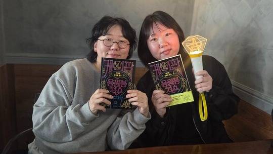 '케이팝 응원봉 걸스'의 저자 일석과 구구 작가가 지난 22일 서울시 성동구의 한 카페에서 인터뷰를 하기 전에 책과 보아 응원봉을 들고 포즈를 취하고 있다. 2026.3.22. 정 숙 시민기자