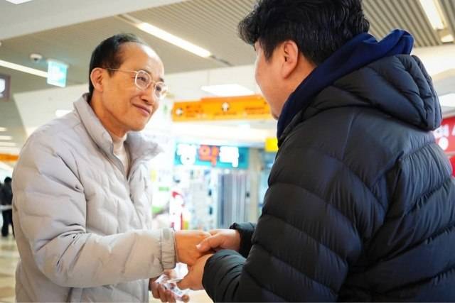 6·3 지방선거에 출마한 일부 국민의힘 예비 후보들이 '당 지우기'에 나섰다. 사진은 흰색 패딩을 입은 추경호 국민의힘 의원이 지난 18일 대구 반월당지하상가를 찾아 시민과 악수하는 모습. /추 의원 페이스북