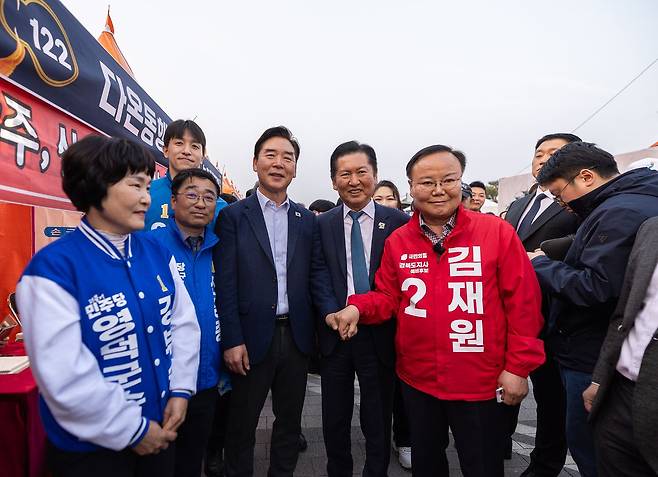 오중기 더불어민주당 경북지사 후보(왼쪽)와 정청래 민주당 대표(오른쪽)가 27일 경북 영덕에서 열린 제29회 대게 축제에서 6ㆍ3 지방선거 경북지사 국민의힘 예비 후보인 김재원 최고위원을 우연히 만나 악수하고 있다. 연합뉴스