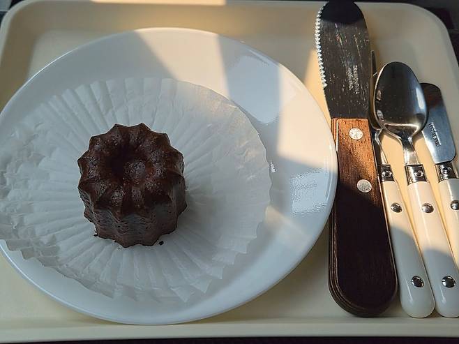 택시 안에는 구매한 빵을 이동 중에 맛볼 수 있도록 테이블도 준비돼 있다. 사진은 정동문화사에서 구입한 까눌레. 이지영 기자