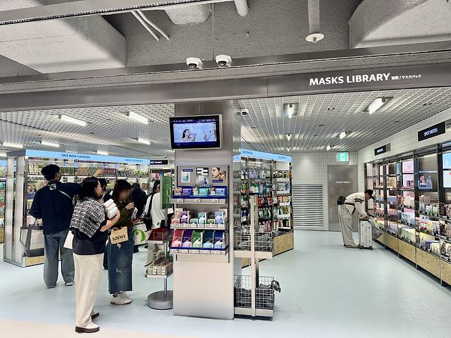 Customers browse sheet masks at Olive Young Central Myeongdong Town in central Seoul. (No Kyung-min/The Korea Herald)