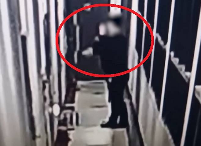 지난 1월 경기 시흥시의 한 아파트 현관문 앞에서 마스크를 쓴 남성이 인분을 던지는 모습. SBS 보도화면 캡처