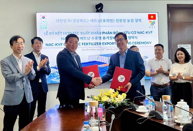 경북 봉화군 농업회사법인 늘푸른(주)와 베트남 국영 비료 유통기업 KVF 관계자들이 26일 베트남 호찌민에서 'K-축분유기질비료' 수출 계약을 체결한 뒤 기념촬영을 하고 있다. (왼쪽 세번째) 늘푸른(주) 이시목 대표와 KVF 관계자가 계약서를 교환하고 있다. 봉화군 제공