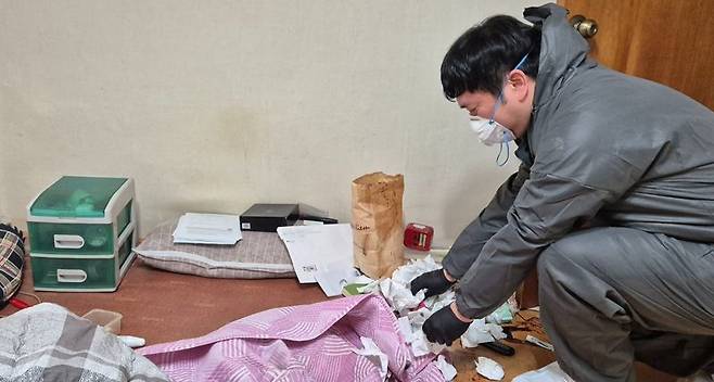 서울 동대문구의 한 반지하 주택 고독사 현장에서 고인의 생애가 담긴 물건들을 조심스럽게 정리하고 있다. 사진=한승곤 기자