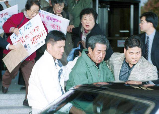 민주화 이후 11년간 도피생활을 하다 1999년 경찰에 자수한 이근안이 시민들의 항의가 쏟아지는 가운데 성남지청에서 서울지검으로 압송되고 있다. 한국일보 자료사진